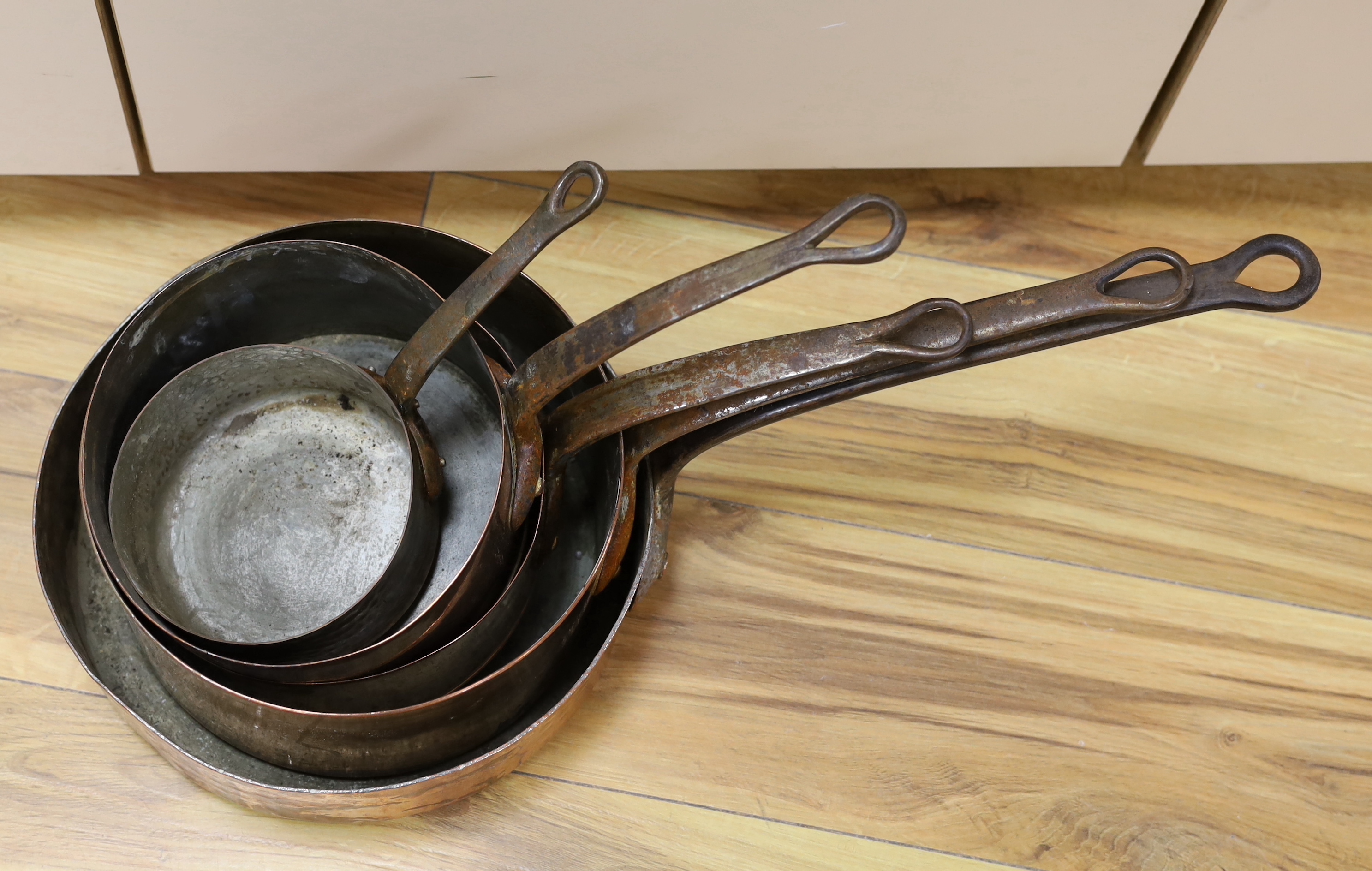 A set of five copper pans, largest diameter 28cm
